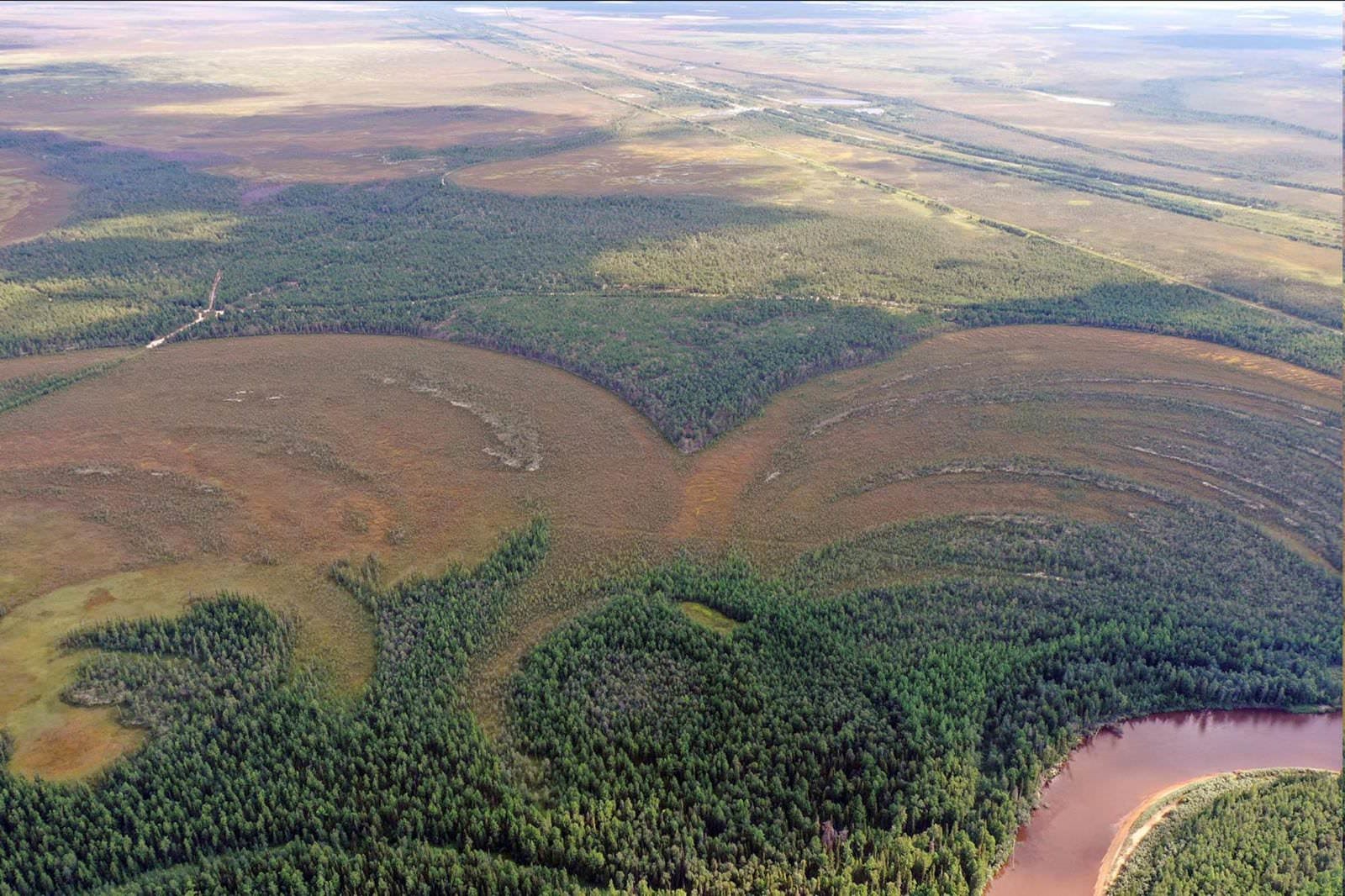 Vue aérienne du village fortifié au sommet d'un terrain surplombant la généreuse rivière Amnya.